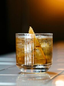 This Japanese Old Fashioned features Suntory Hibiki Whiskey as its star ingredient, complemented by sugar, yuzu bitters for a zesty twist, and a garnish of orange peel.