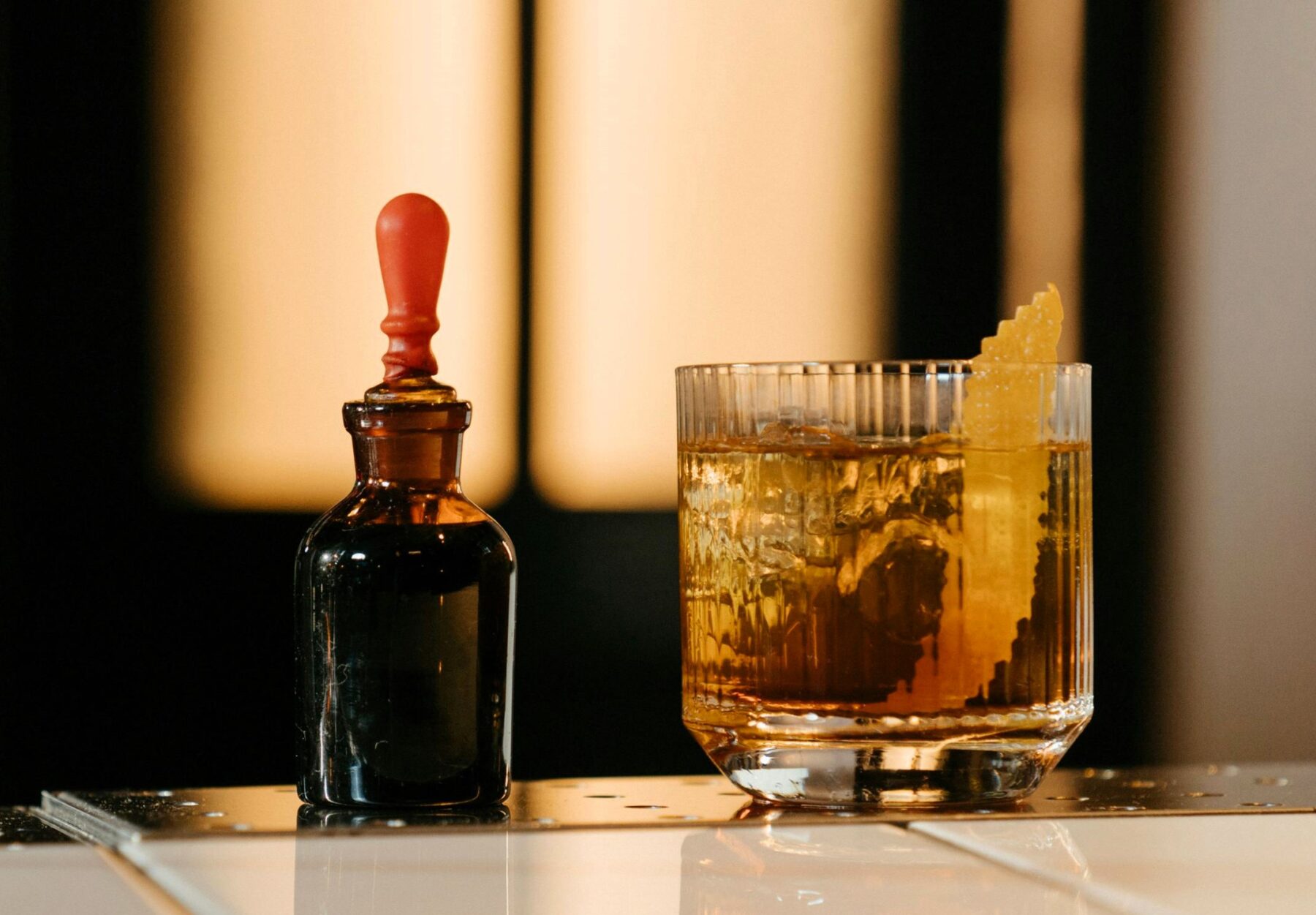 This Japanese Old Fashioned features Suntory Hibiki Whiskey as its star ingredient, complemented by sugar, yuzu bitters for a zesty twist, and a garnish of orange peel.